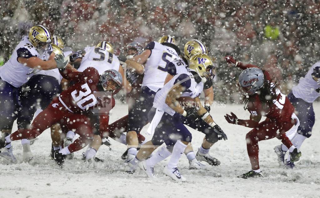 Ted S. Warren Washington running back Myles Gaskin, center, rushes past Washington State defensive lineman Nnamdi Oguayo (30) and linebacker Jahad Woods, right, during the second half of an NCAA college football game, Friday, Nov. 23, 2018, in Pullman, Wash. Washington won 28-15. (AP Photo/Ted S. Warren)