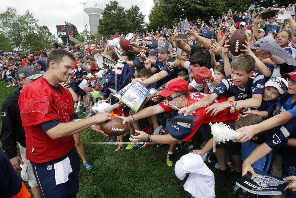 FILE - In this Aug. 3, 2017, file photo, New England Patriots' Tom Brady, left, signs autographs for fans at NFL football training camp in Foxborough, Mass. Tom Brady is an NFL free agent for the first time in his career. The 42-year-old quarterback with six Super Bowl rings said Tuesday morning, March 17, 2020, that he is leaving the New England Patriots. (AP Photo/Steven Senne)