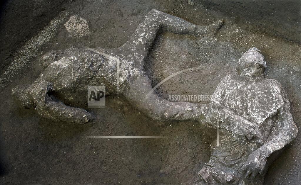 Uncredited The casts of what are believed to have been a rich man and his male slave fleeing the volcanic eruption of Vesuvius nearly 2,000 years ago, are seen in what was an elegant villa on the outskirts of the ancient Roman city of Pompeii destroyed by the eruption in 79 A.D., where they were discovered during recents excavations, Pompeii archaeological park officials said Saturday, Nov. 21, 2020. (Parco Archeologico di Pompei via AP)