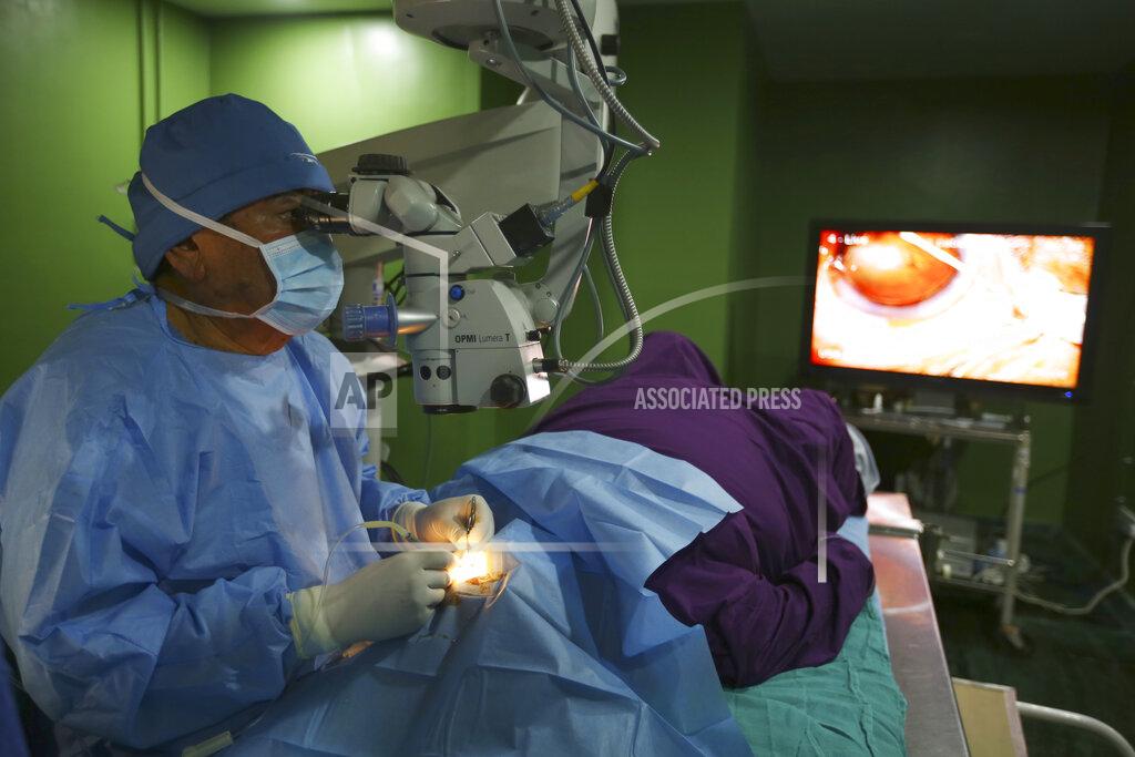 Niranjan Shrestha Dr. Sanduk Ruit performs cataract surgery at the Tilganga Eye Center in Kathmandu, Nepal, March 26, 2021. Nepal’s “God of Sight” eye doctor renowned for his innovative and inexpensive cataract surgery for the poor is taking his work beyond the Himalayan mountains to other parts of the world so there is no more unnecessary blindness in the world. Ruit, who has won many awards for his work and performed some 130,000 cataract surgery in the past three decades, is aiming to expand his work beyond the borders of his home country and the region to go globally. (AP Photo/Niranjan Shrestha)