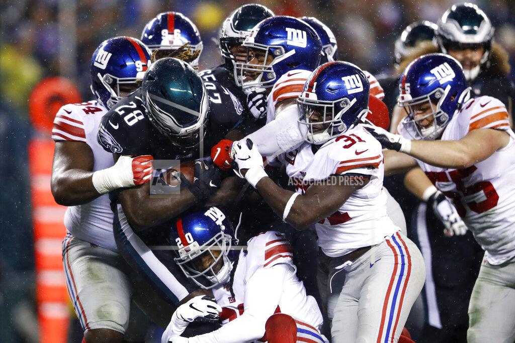 Matt Rourke Philadelphia Eagles' Jay Ajayi (28) is tackled by New York Giants' Dalvin Tomlinson (94), Janoris Jenkins (20), Corey Ballentine (25) and Michael Thomas (31) during the first half of an NFL football game against the New York Giants, Monday, Dec. 9, 2019, in Philadelphia. (AP Photo/Matt Rourke)