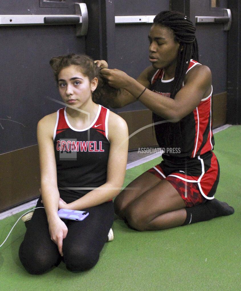 Pat Eaton-Robb FILE - In this Feb. 7, 2019 file photo, Cromwell High School transgender athlete Andraya Yearwood, right, braids the hair of teammate Taylor Santos during a break at a track meet at Hillhouse High School in New Haven, Conn. Between 2017 and 2019, transgender sprinters Yearwood and Terry Miller combined to win 15 championship races, prompting a lawsuit on behalf of four cisgender girls. (AP Photo/Pat Eaton-Robb, File)