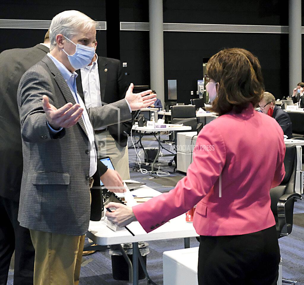 Bob Brown Sen. Mark Obenshain, R-Rockingham, left, and Sen. Barbara Favola, D-Arlington, right, have a discussion following HB2167, the bill dealing with parole passed the Senate, 20-18, during the floor session of the Virginia Senate, which is meeting inside the Science Museum of Virginia in Richmond, Va., Saturday, Feb. 27, 2021. (Bob Brown/Richmond Times-Dispatch via AP)