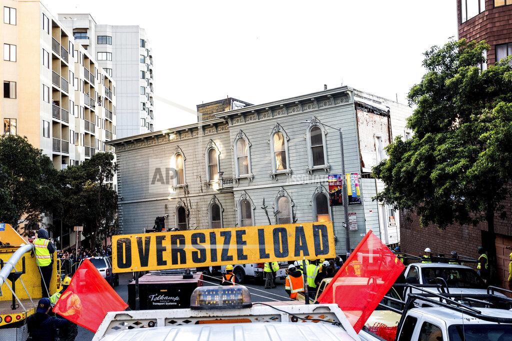 Noah Berger A truck pulls a Victorian home through San Francisco on Sunday, Feb. 21, 2021. The house, built in 1882, was moved to a new location about six blocks away to make room for a condominium development. According to the consultant overseeing the project, the move cost approximately $200,000 and involved removing street lights, parking meters, and utility lines. (AP Photo/Noah Berger)