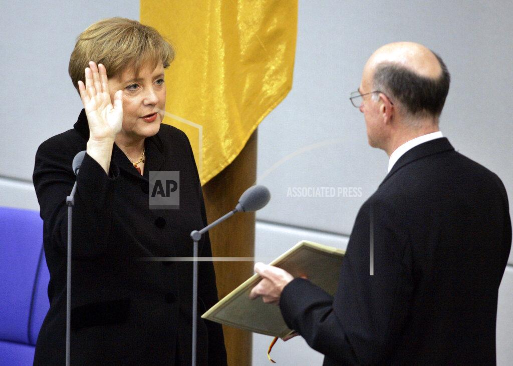 Fritz Reiss FILE - In this Tuesday, Nov. 22, 2005 file photo, newly appointed German chancellor Angela Merkel, left, takes the oath of office in the parliament in Berlin. Angela Merkel, Germany’s first female chancellor, has been praised by many for her pragmatic leadership in a turbulent world and celebrated by some as a feminist icon. But a look at her track record in fighting gender inequality in 16 years running Germany reveals missed opportunities in promoting women's issues. (AP Photo/Fritz Reiss, File)