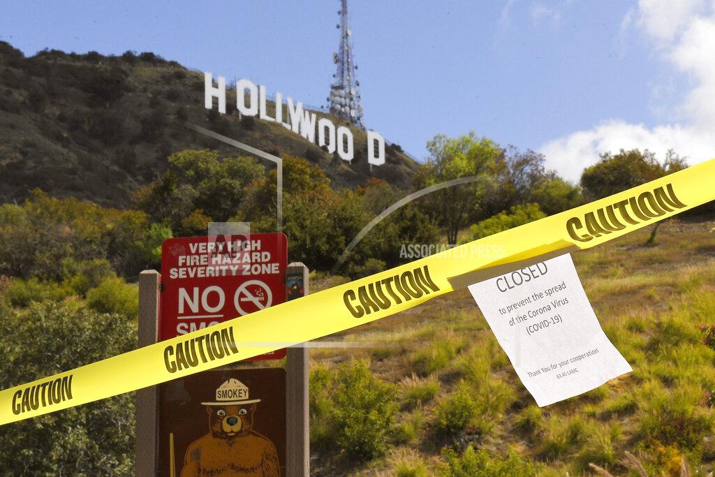 Mark J. Terrill FILE - In this March 28, 2020, file photo, a sign is posted at the closed entrance to Innsdale Trail near the Hollywood sign in Los Angeles, amid the coronavirus pandemic. Now, in early May 2021, California has the lowest case rate in the country. (AP Photo/Mark J. Terrill, File)
