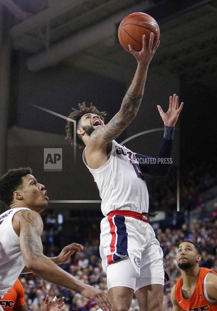 Young Kwak Gonzaga guard Josh Perkins, center, shoots between teammate Brandon Clarke, left, and Pacific guard Brandon McGhee during the first half of an NCAA college basketball game in Spokane, Wash., Thursday, Jan. 10, 2019. (AP Photo/Young Kwak)
