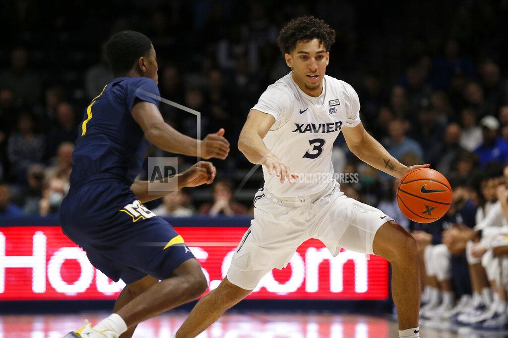 Sam Greene Xavier guard Colby Jones (3) drives against Marquette guard Kameron Jones (1) in the first half of an NCAA college basketball game in Cincinnati, Saturday, Dec. 18, 2021. (Sam Greene/The Cincinnati Enquirer via AP)