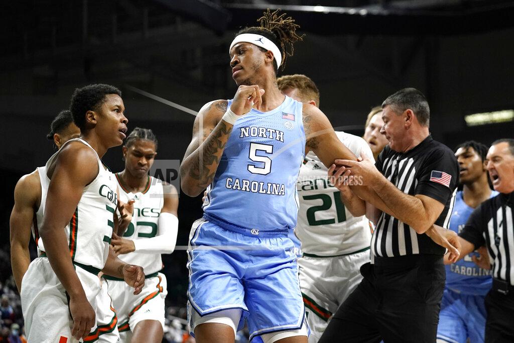 Lynne Sladky North Carolina forward Armando Bacot (5) is pulled away by an official from Miami guard Charlie Moore (3) during the first half of an NCAA college basketball game, Tuesday, Jan. 18, 2022, in Coral Gables, Fla. (AP Photo/Lynne Sladky)