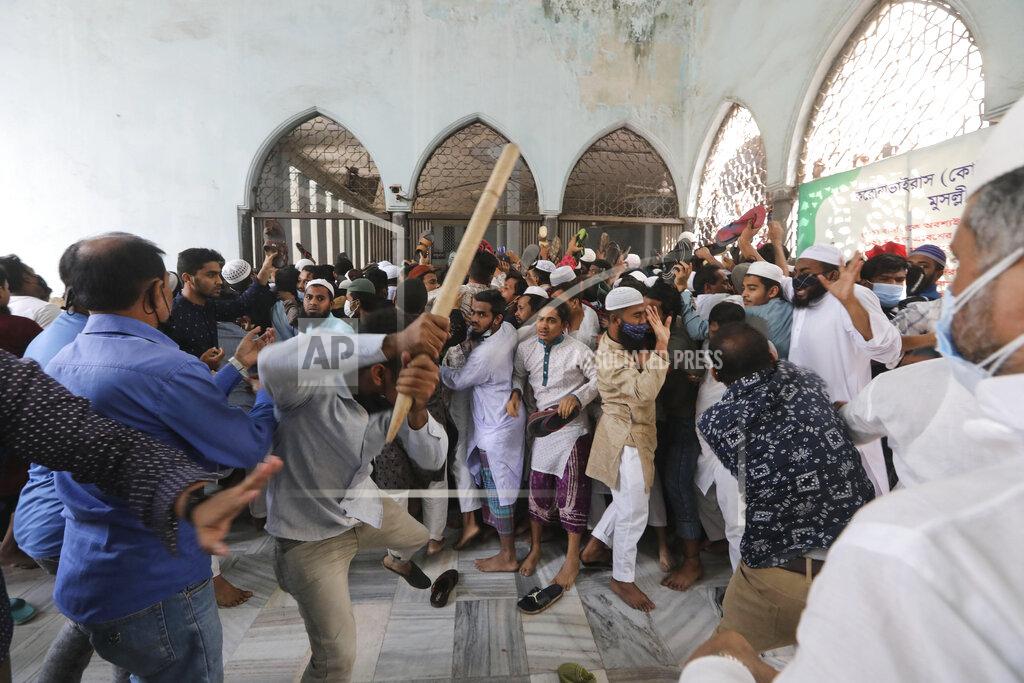 Mahmud Hossain Opu Two factions of protestors clash after Friday prayers at Baitul Mokarram mosque in Dhaka, Bangladesh, Friday, March 26, 2021. Witnesses said violent clashes broke out after one faction of protesters began waving their shoes as a sign of disrespect to Indian Prime Minister Narendra Modi, and another group tried to stop them. Local media said the protesters who tried to stop the shoe-waving are aligned with the ruling Awami League party. The party criticized the other protest faction for attempting to create chaos in the country during Modi’s visit. (AP Photo/Mahmud Hossain Opu)