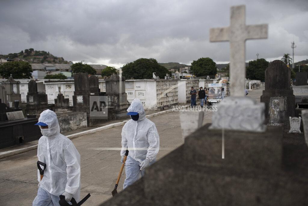 Silvia Izquierdo FILE - In this April 13, 2021, file photo, cemetery workers in protective gear walk to the burial of a woman who died from complications related to COVID-19 at the Inahuma cemetery in Rio de Janeiro, Brazil. The picture is still grim in parts of Europe and Asia as variants of the virus fuel an increase in new cases and the worldwide death toll closes in on 3 million. (AP Photo/Silvia Izquierdo, File)