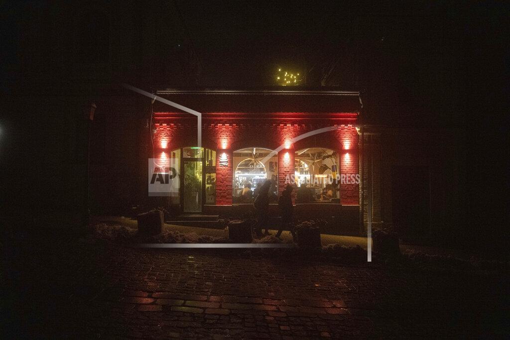 Evgeniy Maloletka People walk past a cafe at the city center which lost electrical power after yesterday's Russian rocket attack in Kyiv, Ukraine, Thursday, Nov. 24, 2022. (AP Photo/Evgeniy Maloletka)