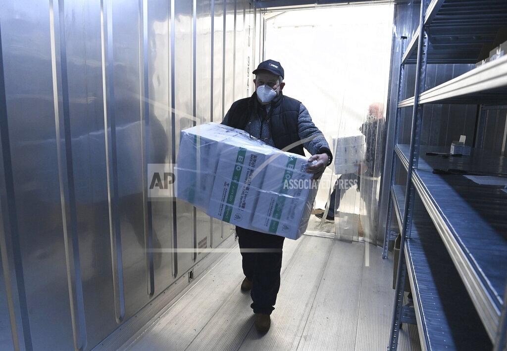 Noemi Bruzak An employee unloads the newly arrived coronavirus vaccines from Chinese pharmaceutical company Sinopharm at the logistics base set up to in the parking lot of the government office in the 13th district of Budapest, Hungary, Monday, March 29, 2021. (Noemi Bruzak/MTI via AP)