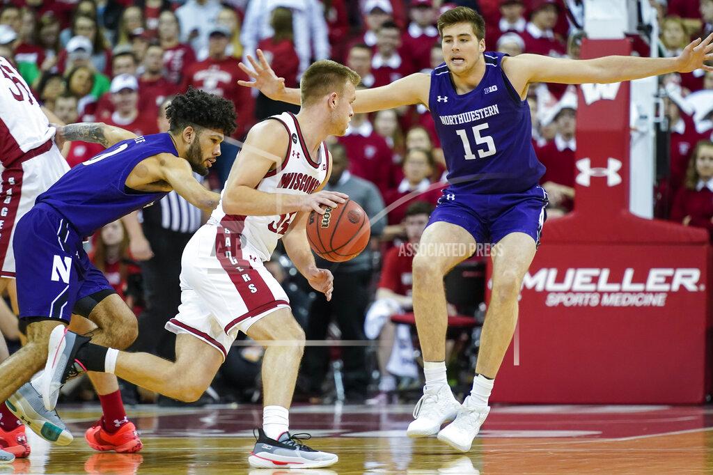 Andy Manis Wisconsin's Brad Davison, center, drives between Northwestern's Boo Buie, left, and Ryan Young (15) during the first half of an NCAA college basketball game Wednesday, March 4, 2020, in Madison, Wis. (AP Photo/Andy Manis)