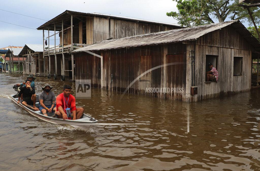 Edmar Barros Residents navigate flooded streets in Anama, Amazonas state, Brazil, Thursday, May 13, 2021. (AP Photo/Edmar Barros)