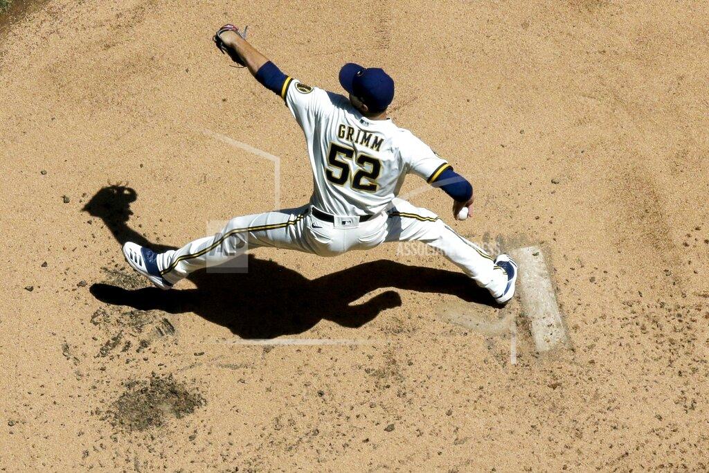 Morry Gash FILE - In this July 13, 2020, file photo, Milwaukee Brewers' Justin Grimm throws during a baseball practice session at Miller Park in Milwaukee. Brewers reliever Grimm and outfielder-first baseman Logan Morrison learned they made the team after reporting to camp as non-roster invitees. The news was particularly sweet for Grimm, who made at least 50 appearances for the Chicago Cubs every season from 2014-17 but has bounced around a few organizations since and spent all of last season in the minors. (AP Photo/Morry Gash, File)