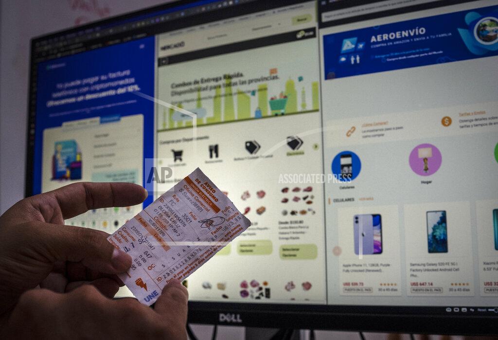 Ramon Espinosa Erich García, a programmer specializing in cryptocurrencies and is an administrator of electronic commerce pages, shows how an electricity bill can be paid through cryptocurrency systems and electronic payments in Havana, Cuba, Friday, May 20, 2022. Some people have used those virtual currencies like Bitcoin to shift money to Cubans electronically. Garcia estimated that about 100,000 have cryptocurrency accounts. (AP Photo/Ramon Espinosa)