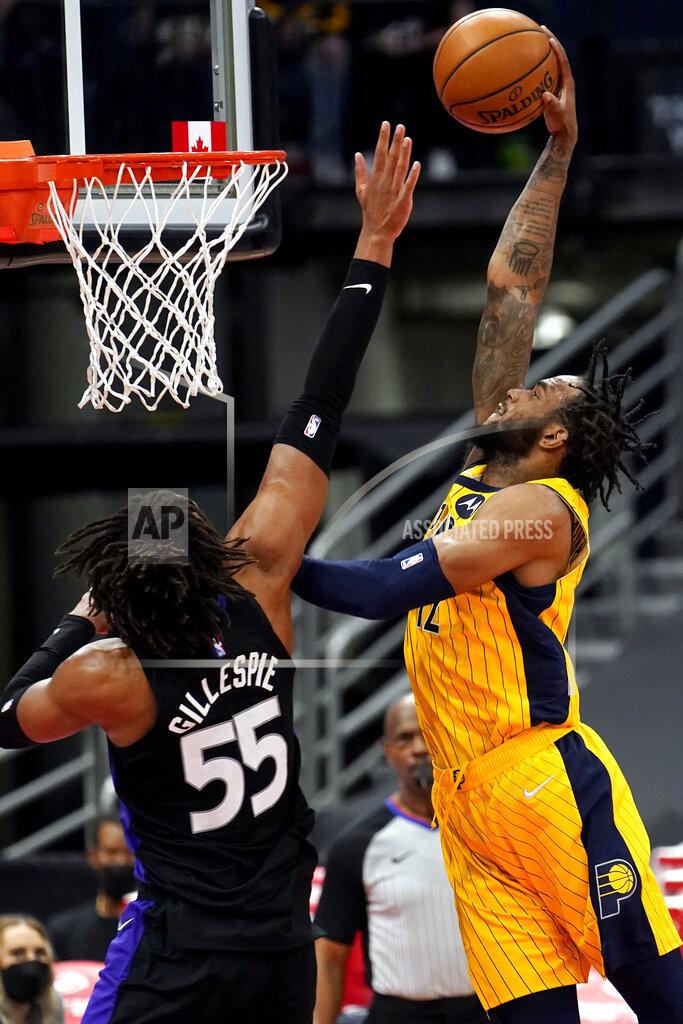 Chris O'meara Indiana Pacers forward Oshae Brissett (12) goes up for a slam dunk in front of Toronto Raptors forward Freddie Gillespie (55) during the second half of an NBA basketball game Sunday, May 16, 2021, in Tampa, Fla. (AP Photo/Chris O'Meara)