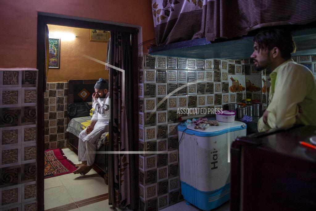 Altaf Qadri Haroon, left, who saw his 32 year-old brother being shot and killed by his Hindu neighbors during the February 2020 communal riots, breaks down while speaking to the Associated Press inside his home in North Ghonda, one of the worst riot affected neighborhood, in New Delhi, India, Friday, Feb. 19, 2021. As the first anniversary of bloody communal riots that convulsed the Indian capital approaches, Muslim victims are still shaken and struggling to make sense of their struggle to seek justice. (AP Photo/Altaf Qadri)