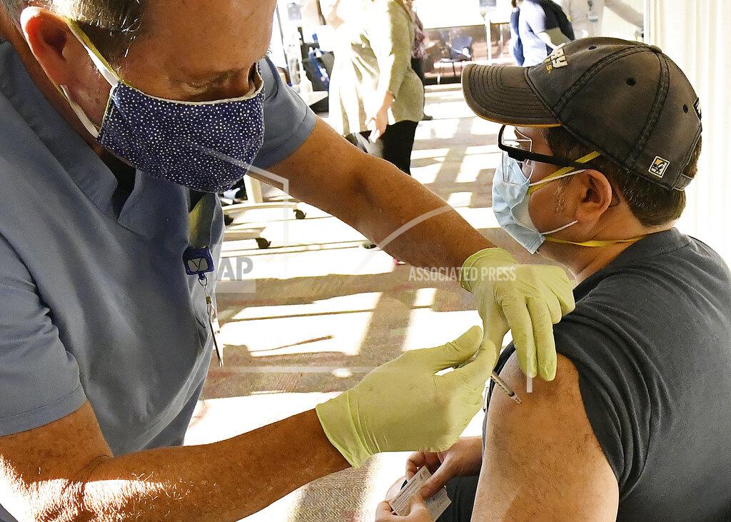 Dr. Angel Temponi, left, administers the second dose of the Moderna vaccine to Dr. Barton Bernstein Tuesday, Jan. 19, 2021 at Yuma Regional Medical Center in Yuma, Ariz. (Randy Hoeft/The Yuma Sun via AP)