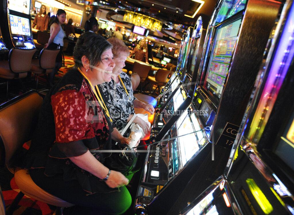 FILE - In this July 15, 2011 file photo, Karen Lingermuth, of Niles, Ill., plays the slots during a special VIP event at the Rivers Casino in the Chicago suburb of Des Plaines, Ill. Chicago is taking a big step toward building its long-awaited first casino. Starting Thursday, April 22, 2021, city officials are officially seeking bids from companies interested in what's being billed as a "world-class" resort scheduled to open by 2025. (Mark Welsh/Daily Herald via AP, File)