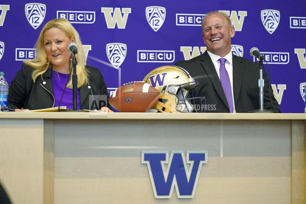 Ted S. Warren Washington athletic director Jen Cohen, left, and Kalen DeBoer, right, react during a news conference, Tuesday, Nov. 30, 2021, in Seattle, to introduce DeBoer as the new head NCAA college football coach at the University of Washington. DeBoer has spent the past two seasons as head football coach at Fresno State. (AP Photo/Ted S. Warren)