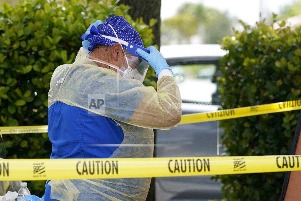 Lynne Sladky A health care worker with Nomi Health puts on a protective face shield while working at a Miami-Dade County COVID-19 testing site, Monday, July 26, 2021, in Hialeah, Fla. Florida accounted for a fifth of the nation's new infections last week, more than any other state, according to the U.S. Centers for Disease Control and Prevention. (AP Photo/Lynne Sladky)
