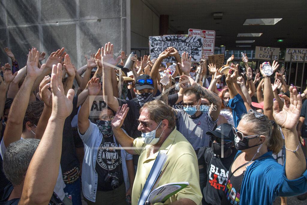 Chris Granger New Orleans Renters Rights Assembly protesters hold their hands in the air as they block people, bottom center, from entering First City Court near New Orleans City Hall on Thursday, July 30, 2020. The group prevented legal professionals and others from entering the building. (Chris Granger/The Advocate via AP)