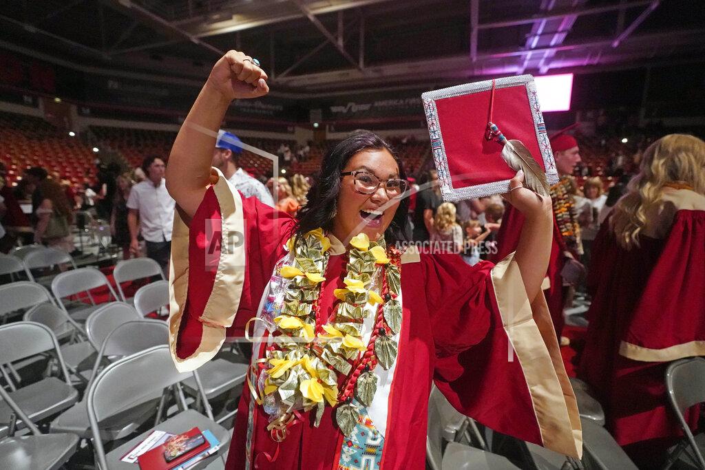 Rick Bowmer Amryn Tom reacts after graduating from Cedar City High School on Wednesday, May 25, 2022, in Cedar City, Utah. Tom is wearing an eagle feather given to her by her mother and a cap that a family friend beaded. (AP Photo/Rick Bowmer)