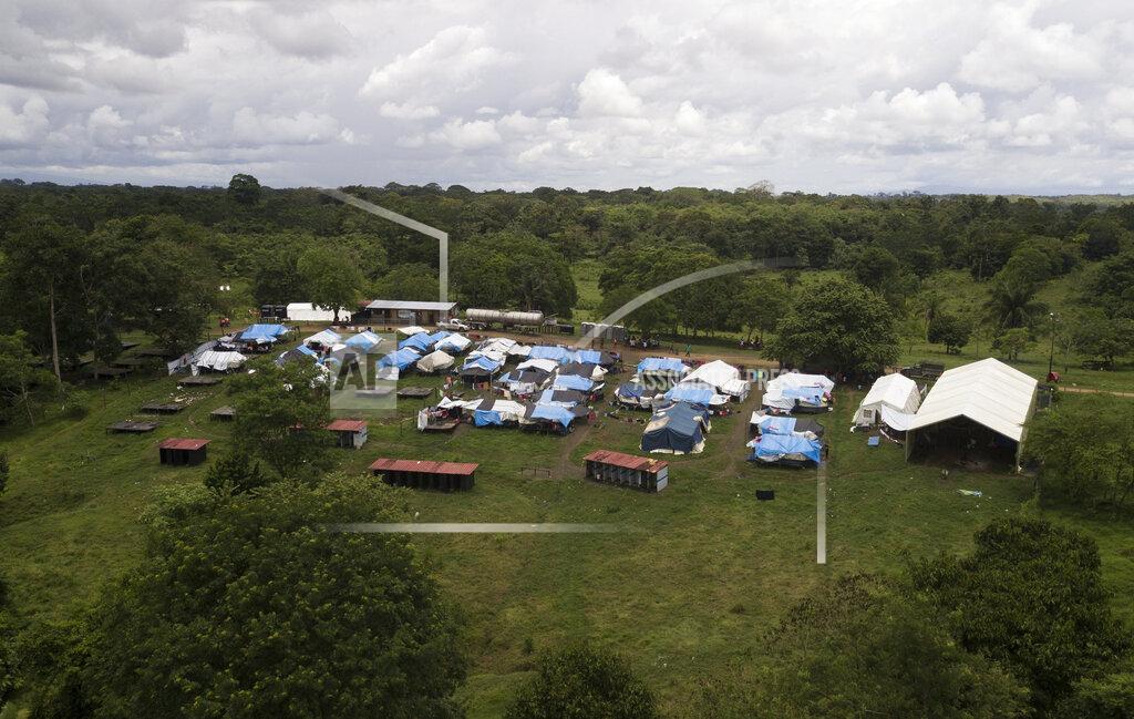 Arnulfo Franco The Lajas Blancas migrant camp stands, amid the new coronavirus pandemic in Darien province, Panama, Saturday, Aug. 29, 2020. The camp is in a grassy field with tarps on wooden platforms packed tight between a dirt road and the brown waters the Chucunaque river. (AP Photo/Arnulfo Franco)