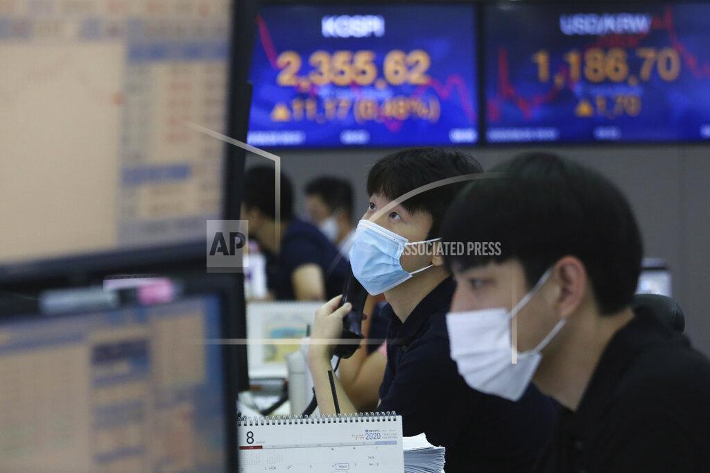 A currency trader watches monitors at the foreign exchange dealing room of the KEB Hana Bank headquarters in Seoul, South Korea, Friday, Aug. 28, 2020. Asian markets were mostly higher Friday after the Federal Reserve said it might keep interest rates low even if inflation rises, in a major overhaul to its strategy. (AP Photo/Ahn Young-joon)