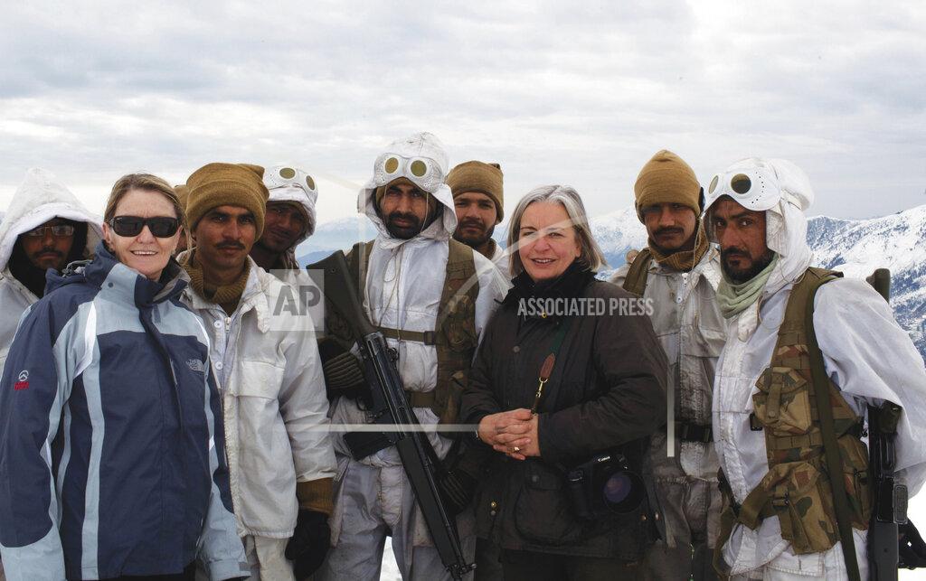 Uncredited FILE - In this Feb. 2012 photo, Kathy Gannon, front left, AP special correspondent for Afghanistan and Pakistan, and veteran AP photographer Anja Niedringhaus, third right, pose with Pakistani soldiers in the remote border area opposite Afghanistan's northeastern Kunar province. The AP team was documenting Pakistan's role in fighting Islamic militants in the region. Niedringhaus, 48, was killed and Gannon was wounded on Friday, April 4, 2014 when an Afghan policeman opened fire while they were sitting in their car in eastern Afghanistan. (AP Photo/File)
