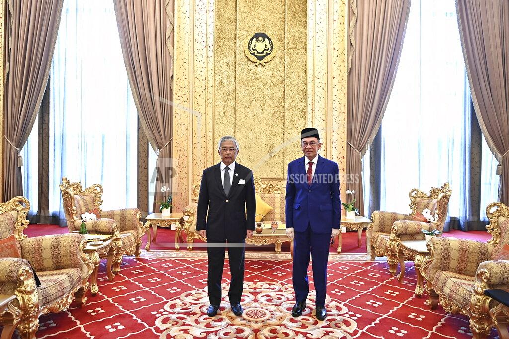 Uncredited In this handout photo provided by the Malaysian National Palace, The King of Malaysia, Sultan Abdullah Sultan Ahmad Shah, left, and opposition leader Anwar Ibrahim pose for photographs inside the Royal Palace in Kuala Lumpur, Malaysia, Tuesday, Oct, 13, 2020. Anwar said he would present the monarch with "strong and convincing" documentary evidence of the support he has from lawmakers, which would allow him to unseat Prime Minister Muhyiddin Yassin. (Malaysian National Palace via AP)