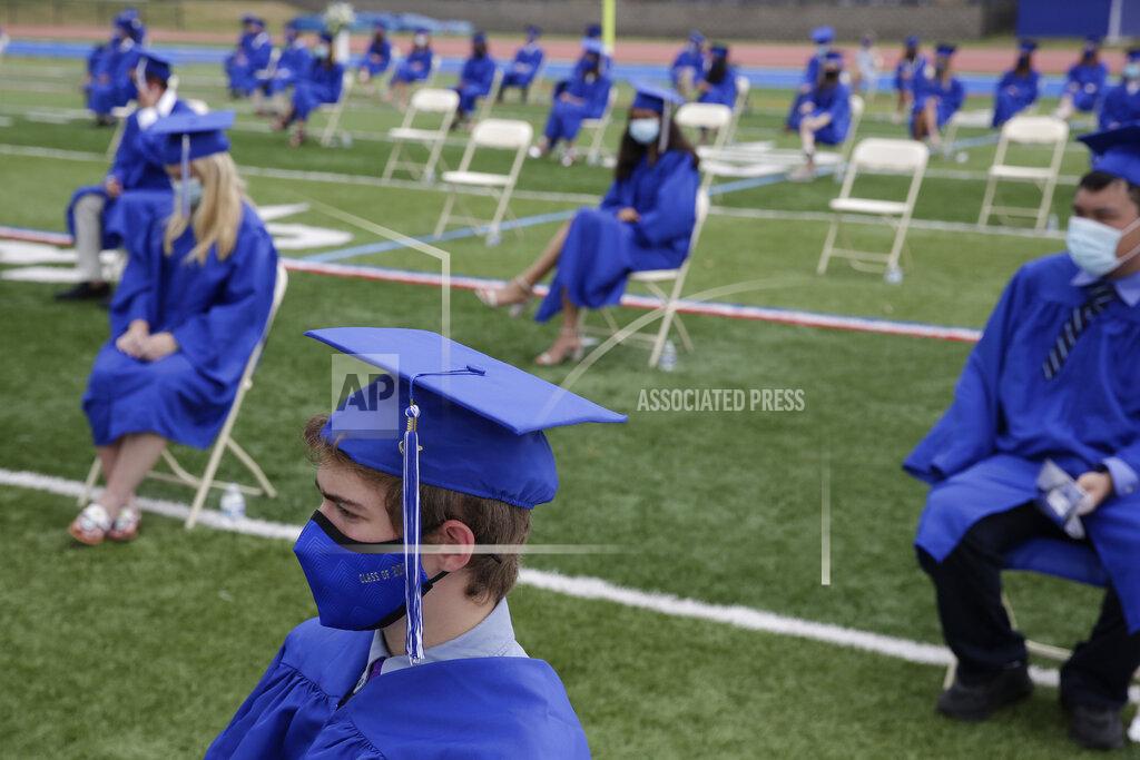 Seth Wenig Graduating students practice socially distance by sitting far apart during a graduation ceremony at Millburn High School in Millburn, N.J., Wednesday, July 8, 2020. This week New Jersey saw the resumption of youth day camps, in-person summer school and school graduation ceremonies, capped at 500 people and required to be outside. (AP Photo/Seth Wenig)