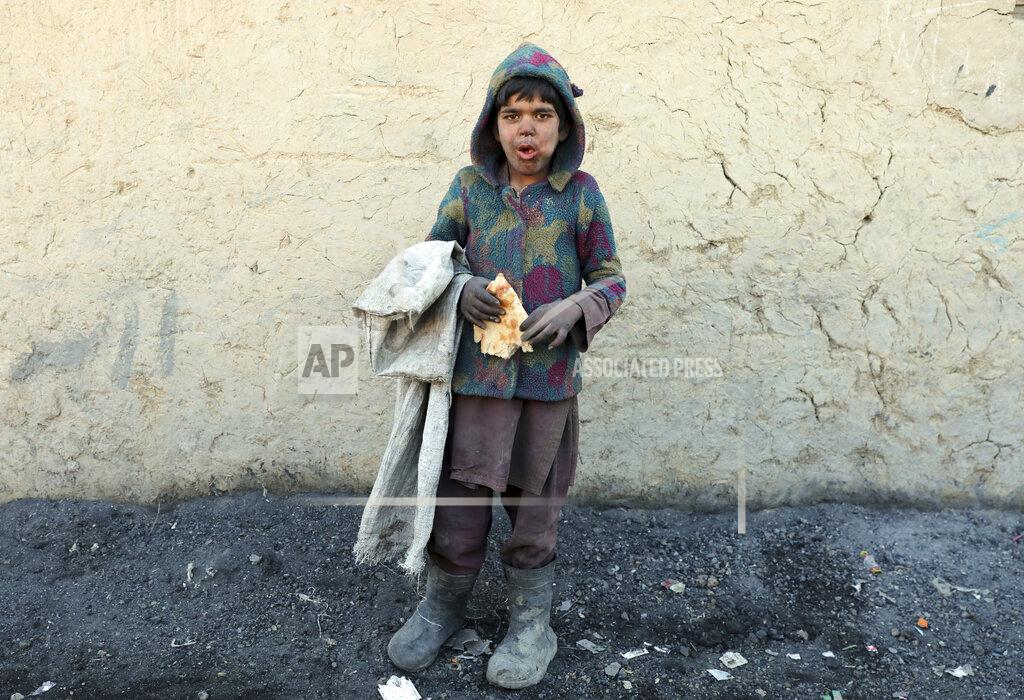 Rahmat Gul An internally displaced boy poses for a photograph outside his temporary home in the city of Kabul, Afghanistan, Wednesday, Dec. 30, 2020. Save the Children has warned that more than 300,000 Afghan children face freezing winter conditions that could lead to illness, in the worst cases death, without proper winter clothing and heating. (AP Photo/Rahmat Gul)