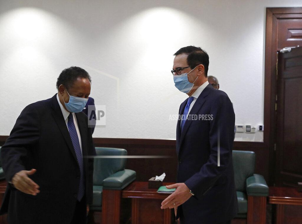 Uncredited Sudanese Prime Minister Abdullah Hamdok, right, welcomes US Treasury Secretary Steven Mnuchin to the Cabinet Building, in Khartoum, Sudan, Wednesday, Jan. 6, 2021. The U.S. and Sudan have agreed to settle the African country's debt to the World Bank. The move comes after Mnuchin arrived in Sudan, the first visit by a senior American official since President Donald trump removed Sudan from the list of state sponsors of terrorism. (AP Photo)
