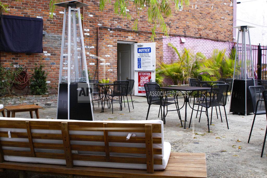 An outdoor seating area is seen at the NOLA Art Bar in New Orleans, Saturday, Jan. 30, 2021. DJ Johnson’s business — NOLA Art Bar — opened just six weeks before the pandemic-related shutdowns last March. It's been a struggle, but he’s still open nearly a year later. (AP Photo/Dorthy Ray)