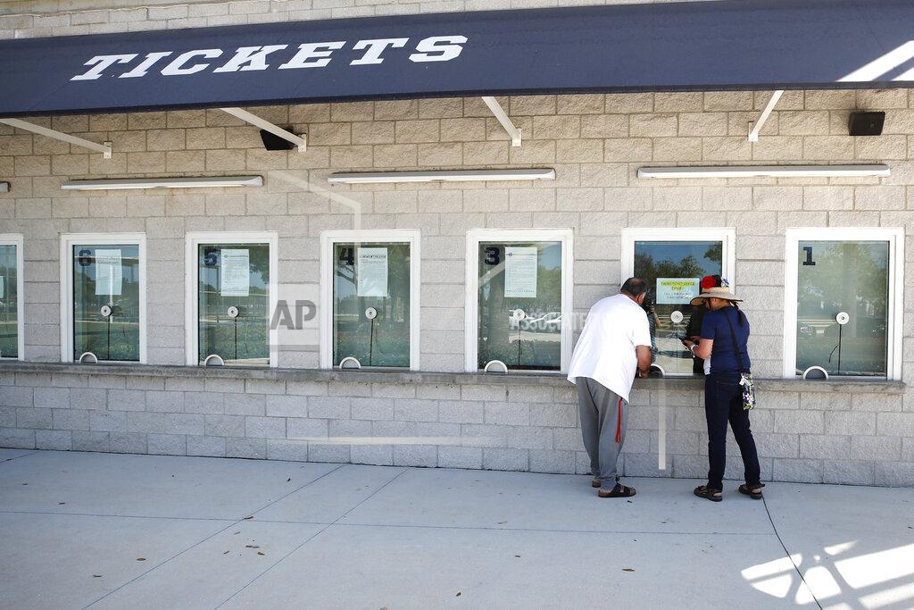 Elise Amendola Baseball fans stand at the window for ticket refunds outside Hammond Stadium, Monday, March 16, 2020, in Fort Myers, Fla., after Major League Baseball suspended the rest of its spring training game schedule because of the coronavirus outbreak. Big league managers say that Major League Baseball has instructed them to prepare for spring training to start on time in mid-February despite uncertainty around the coronavirus. Tampa Bay Rays manager Kevin Cash said Wednesday, Dec. 16, 2020, that officials from the commissioner's office had a meeting with managers Tuesday an expressed optimism about opening spring camps as scheduled. (AP Photo/Elise Amendola)