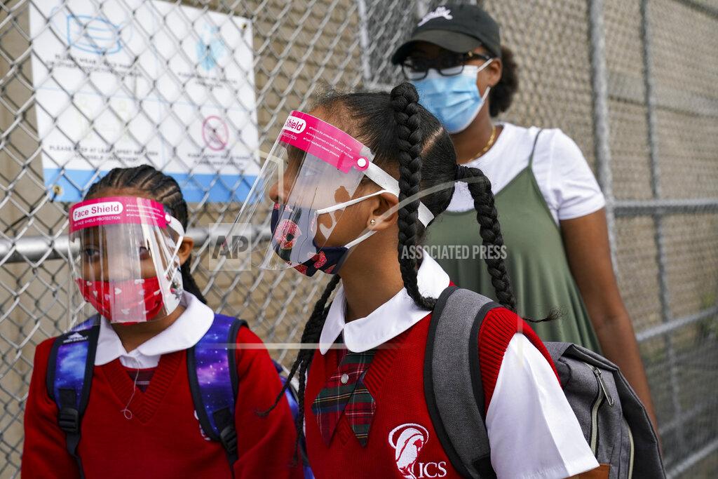 John Minchillo FILE - In this Sept. 9, 2020, file photo, students wear protective masks as they arrive for classes at the Immaculate Conception School while observing COVID-19 prevention protocols in The Bronx borough of New York. New York City has again delayed the planned start of in-person learning for most of the more than 1 million students in its public school system. Mayor Bill de Blasio announced Thursday, Sept. 17, that most elementary school students would do remote-only learning until Sept. 29. Middle and high schools would stay remote through Oct. 1.(AP Photo/John Minchillo)