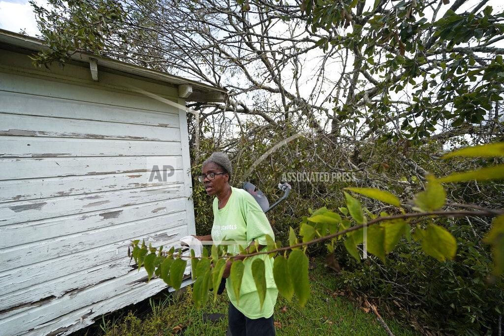 Gerald Herbert Wyna Dennis shows the damage to her home from fallen trees before she leaves Lake Charles, La., in the aftermath of Hurricane Laura, Sunday, Aug. 30, 2020. (AP Photo/Gerald Herbert)