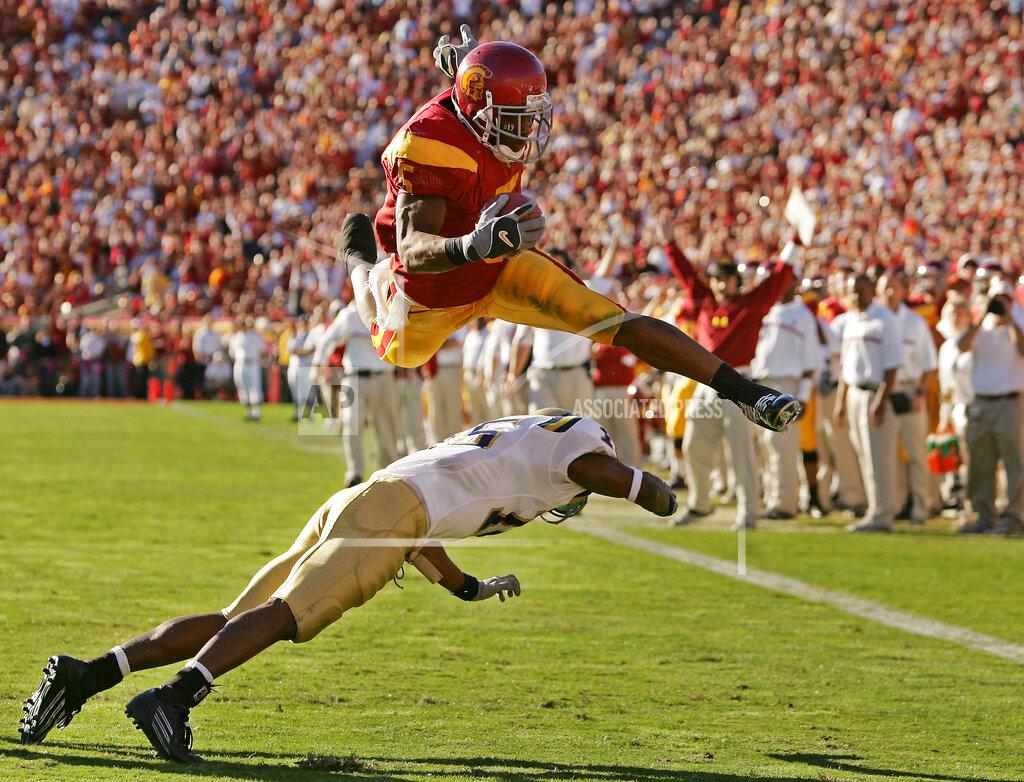 Chris Carlson FILE - In this Dec. 3, 2005, file photo, Southern California's Reggie Bush leaps over UCLA defender Marcus Cassel as he rushes 13 yards for a touchdown in the second quarter of their game at the Los Angeles Memorial Coliseum. USC set a record by going 33 straight polls as No. 1 from 2003-05. The Trojans weren’t just the best team in college football, they were also arguably the coolest, with the charismatic, laid-back Carroll leading stars like quarterback Matt Leinart and running back Reggie Bush to victory after victory. (AP Photo/Chris Carlson, File)