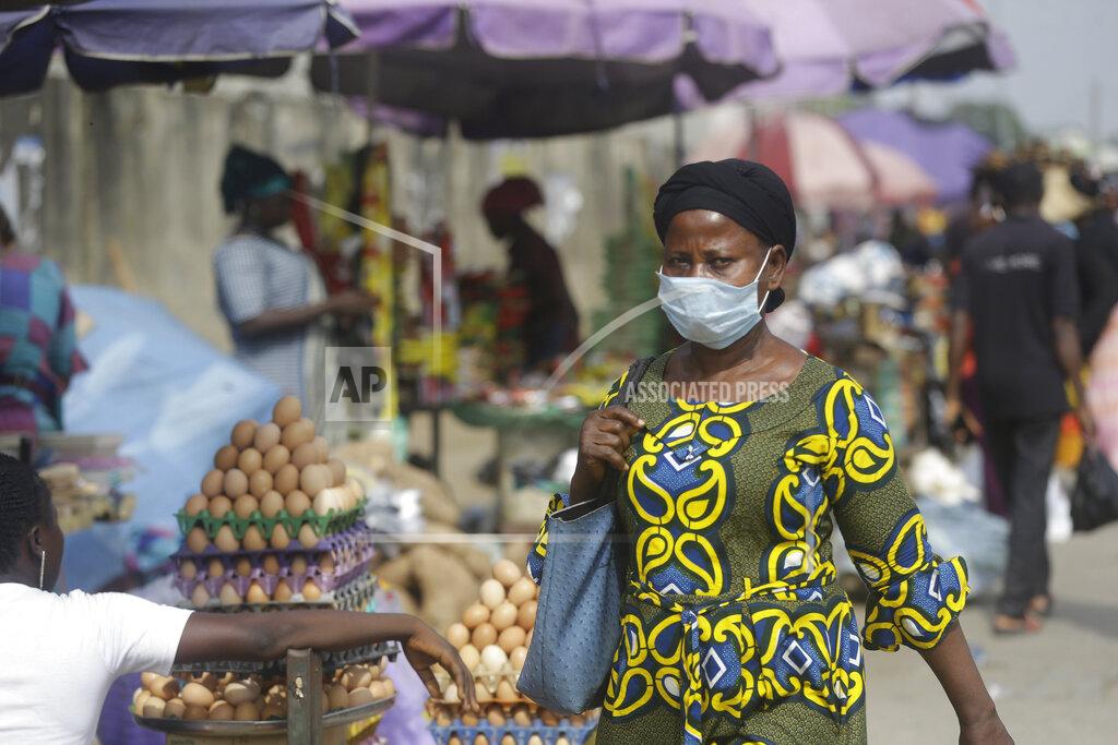 Sunday Alamba A woman wearing a face mask to protect against coronavirus, walks on a street, in Lagos, Nigeria , Thursday, Dec. 31, 2020. A Nigerian scientist has spent the holiday season in his laboratory doing genetic sequencing to learn more about the country’s COVID-19 variant, as cases increase in the country. Virologist Sunday Omilabu says the information he gathers about the variant will help battle the spread of the disease in Nigeria, Africa’s most populous country with 196 million people. (AP Photo/Sunday Alamba)