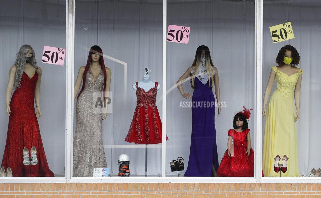 Eric Gay Sale signs are posted on a display window with mask covered mannequins at a dress shop, Thursday, July 30, 2020, in McAllen,Texas. (AP Photo/Eric Gay)