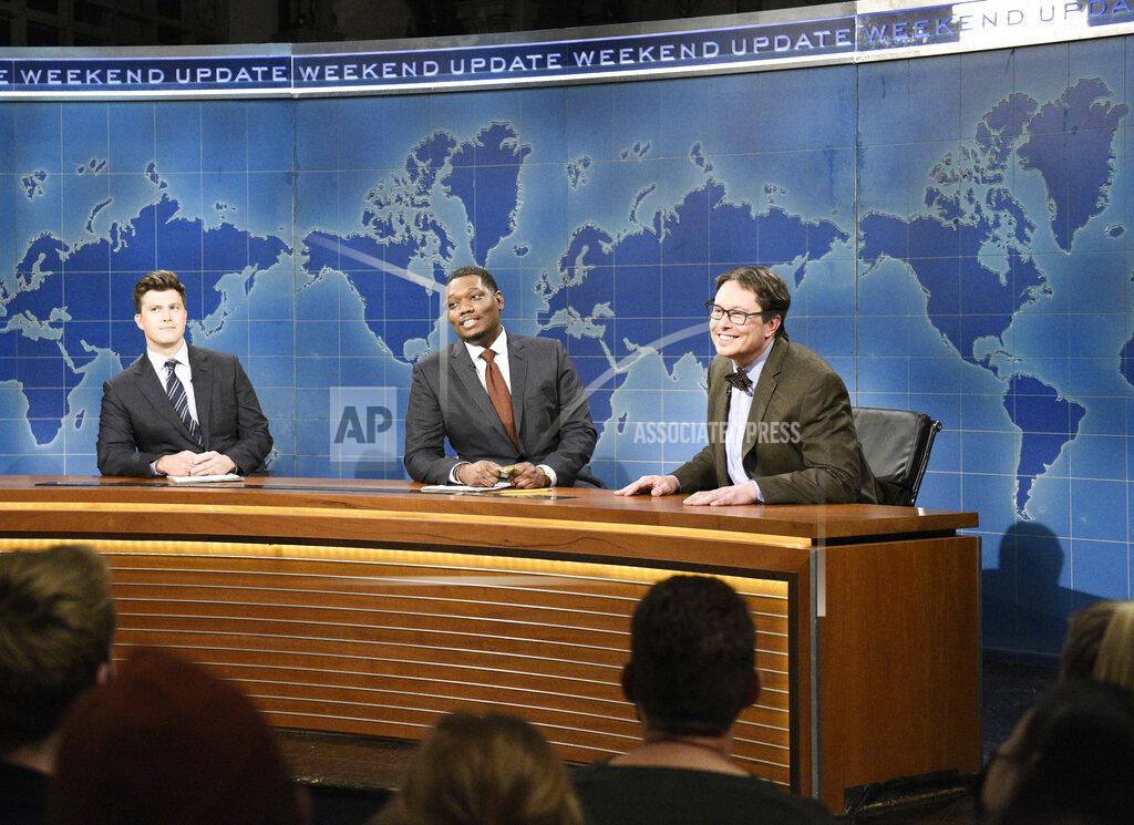 Will Heath This image released by NBC shows, from left, Colin Jost, Michael Che, and host Elon Musk as financial expert Lloyd Ostertag during the "Weekend Update" sketch on "Saturday Night Live," in New York on May 8, 2021. (Will Heath/NBC via AP)