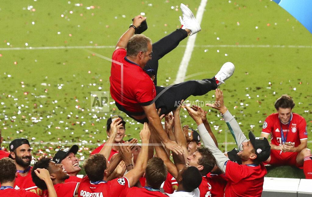 Miguel A. Lopes Bayern's head coach Hans-Dieter Flick is tossed in the air by his players as they celebrate after winning the Champions League final soccer match between Paris Saint-Germain and Bayern Munich at the Luz stadium in Lisbon, Portugal, Sunday, Aug. 23, 2020. (Miguel A. Lopes/Pool via AP)