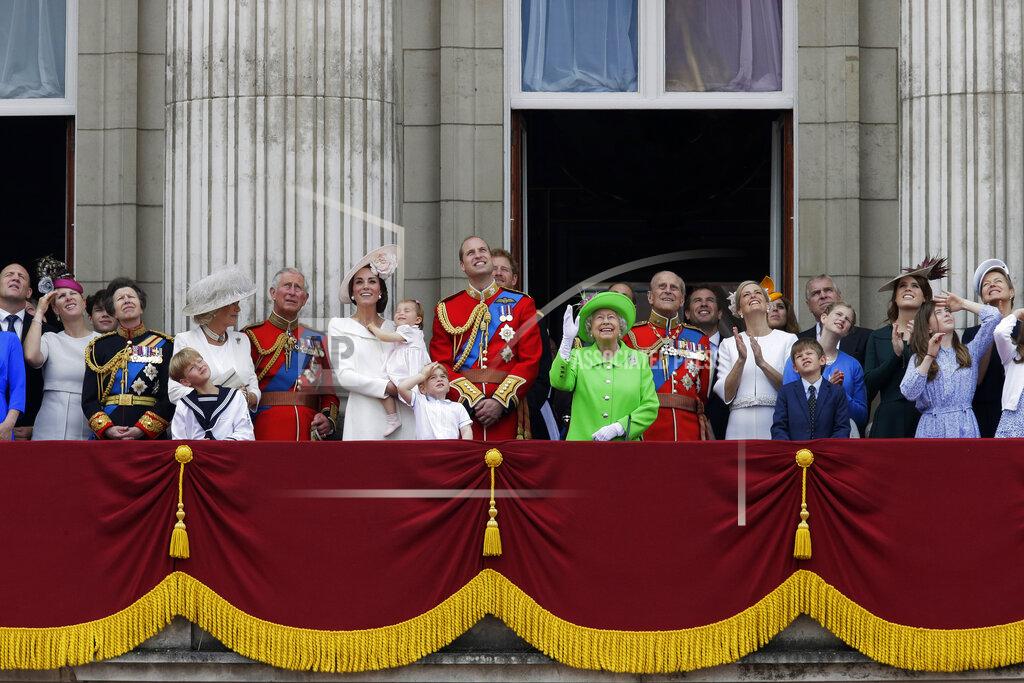 Tim Ireland FILE - In this June 11, 2016 file photo, Britain's Queen Elizabeth II waves as she watches the flypast, with Prince Philip, to right, Prince William, centre, with his son Prince George, front, Kate, Duchess of Cambridge holding Princess Charlotte, centre left, with The Prince of Wales standing with The Duchess of Cornwall, and Princess Anne, fourth left, on the balcony during the Trooping The Colour parade at Buckingham Palace, in London. The timing couldn’t be worse for Harry and Meghan. The Duke and Duchess of Sussex will finally get the chance to tell the story behind their departure from royal duties directly to the public on Sunday, March 7, 2021 when their two-hour interview with Oprah Winfrey is broadcast. (AP Photo/Tim Ireland, File)