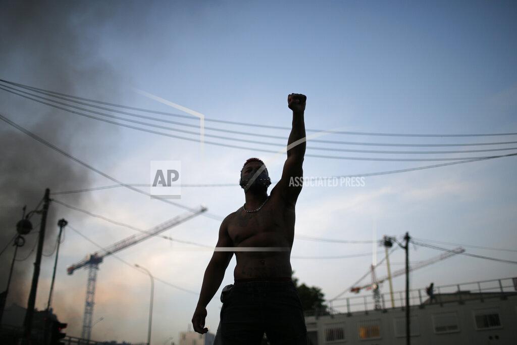 Rafael Yaghobzadeh A protester raises his fist during a demonstration Tuesday, June 2, 2020. Paris riot officers fired tear gas as scattered protesters threw projectiles and set fires at an unauthorized demonstration against police violence and racial injustice. Several thousand people rallied peacefully for two hours around the main Paris courthouse in homage to George Floyd and to Adama Traore, a French black man who died in police custody. (AP Photo/Rafael Yaghobzadeh)