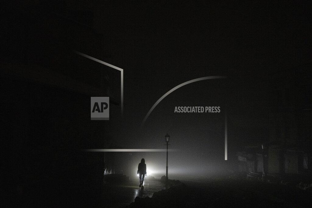 Evgeniy Maloletka A woman walks at the city center which lost electrical power after yesterday's Russian rocket attack in Kyiv, Ukraine, Thursday, Nov. 24, 2022. (AP Photo/Evgeniy Maloletka)