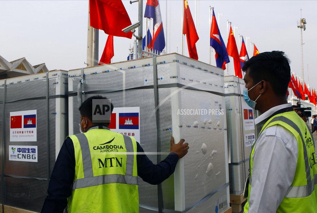 Heng Sinith Workers pull boxes loaded with COVID-19 vaccines before a handing over ceremony at Phnom Penh International Airport, in Phnom Penh, Cambodia, Sunday, Feb. 7, 2021. Cambodia on Sunday received its first shipment of COVID-19 vaccine, a donation of 600,000 doses from China, the country's biggest ally. Beijing has been making such donations to several Southeast Asian and African nations in what has been dubbed "vaccine diplomacy," aimed especially at poorer countries like Cambodia. (AP Photo/Heng Sinith)