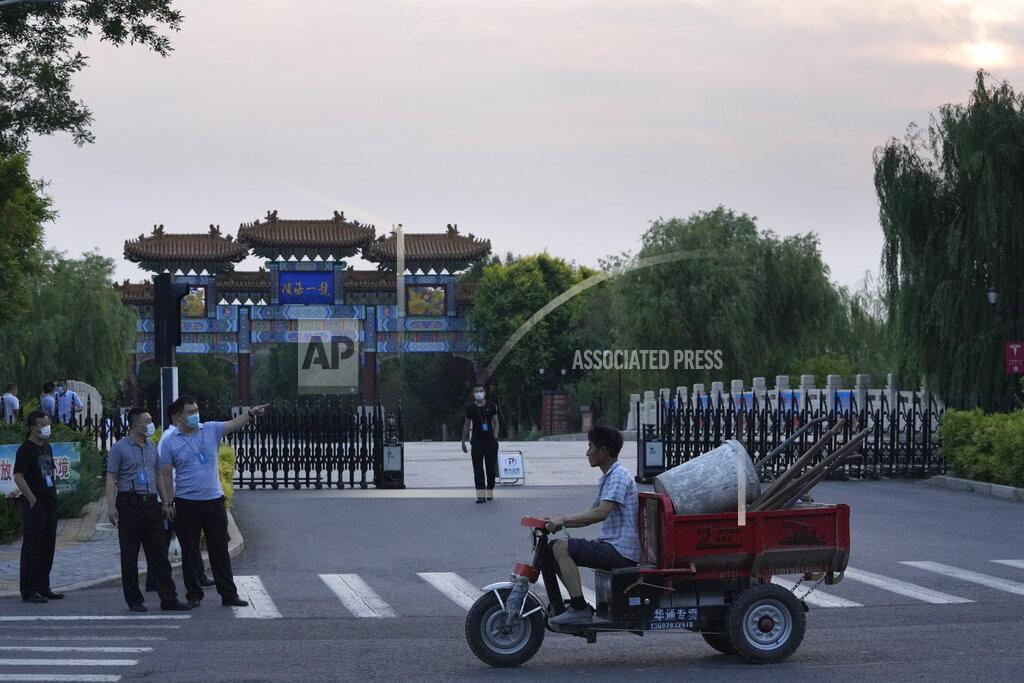 Ng Han Guan A worker transporting work tools pass by security personnel outside the Tianjin Binhai No. 1 Hotel where U.S. and Chinese officials are expected to hold talks in Tianjin municipality in China on Sunday, July 25, 2021. Deputy Secretary of State Wendy Sherman travelled to China this weekend on a visit that comes as tensions between Washington and Beijing soar on multiple fronts, the State Department said Wednesday. (AP Photo/Ng Han Guan)